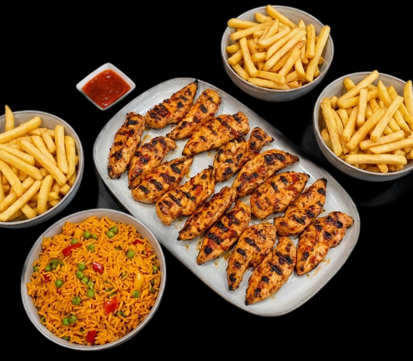 A Lamego's family platter spread of grilled chicken, rice and fries